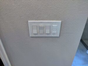 Wall with multiple light switches and a smart timer switch installed by Heck Electric, LLC in Everett, WA