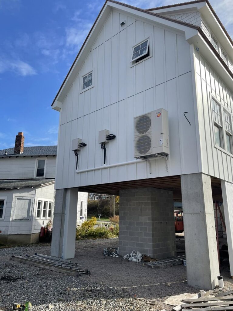 Multiple mini-split condenser units installed on the side of a new construction house by Foremost Mechanical Services in Hartford, CT.