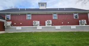 Multiple outdoor mini-split units installed on the side of a building by Blue's Mini Splits LLC in Dover, NH