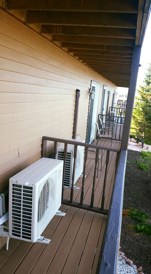 Multiple mini-split outdoor units installed on a residential balcony by Maine Thermal Energy Services in Ellsworth, ME