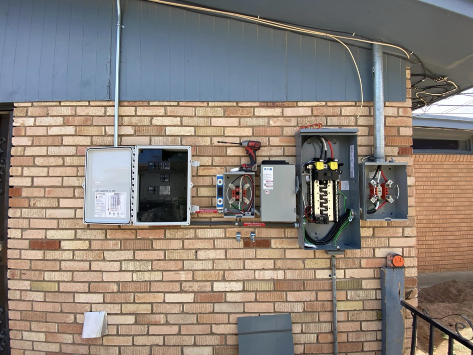 Multiple open electrical panels and meters on a brick wall, showcasing an electrical service upgrade by Flores power solutions in El Paso, TX.