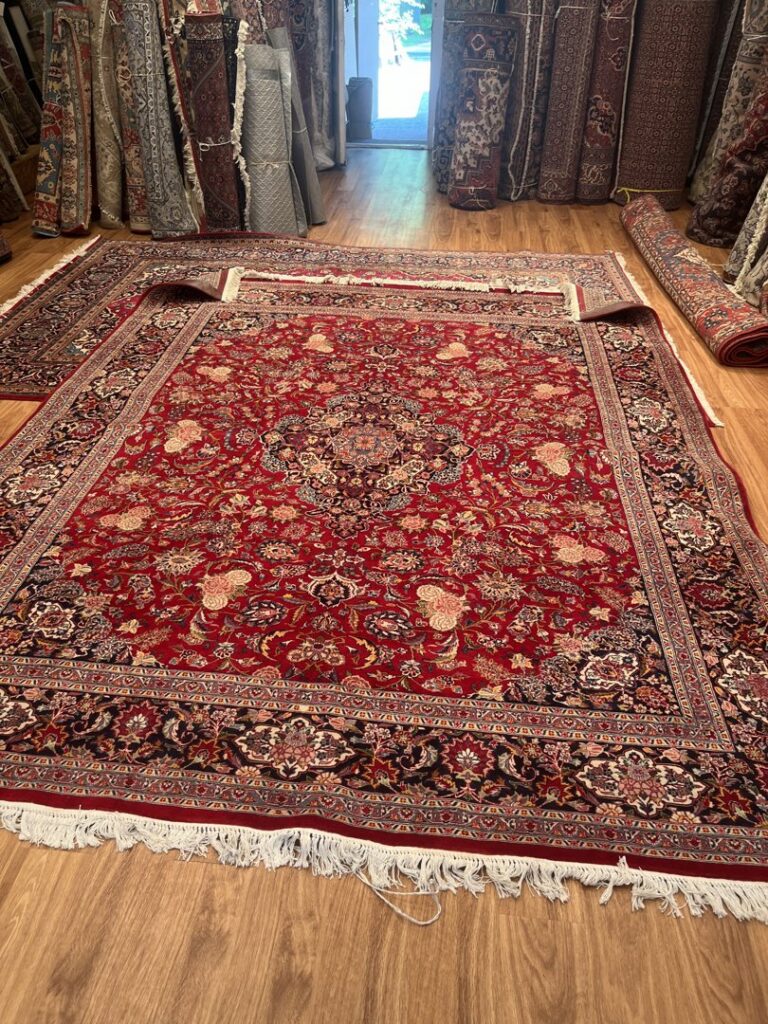 Multiple vibrant oriental rugs laid out for display in the showroom of Borokhim's Oriental Rugs in Madison, WI.