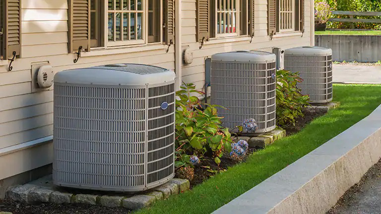 Multiple outdoor AC condenser units installed outside a building by Emerald Air in Wichita, KS.