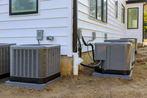 Multiple outdoor AC condenser units installed next to a building by Torres HVAC LLC in Reno, NV.