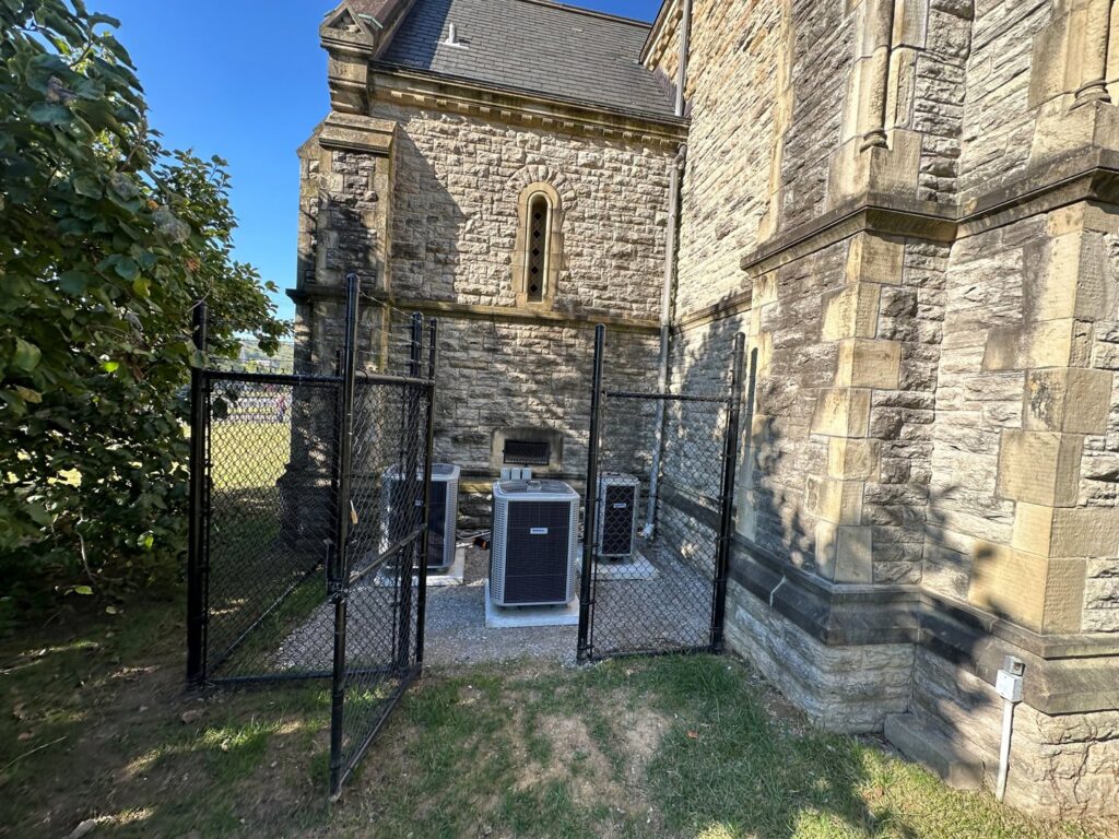 Multiple outdoor air conditioning units installed behind a protective fence by Cafco Services in Cincinnati, OH.