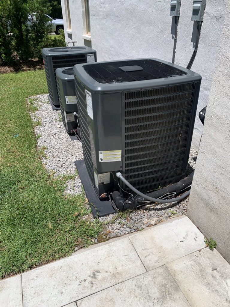 Three outdoor air conditioning units installed next to a building by Get RiTe A/C & Heating in Madisonville, LA.
