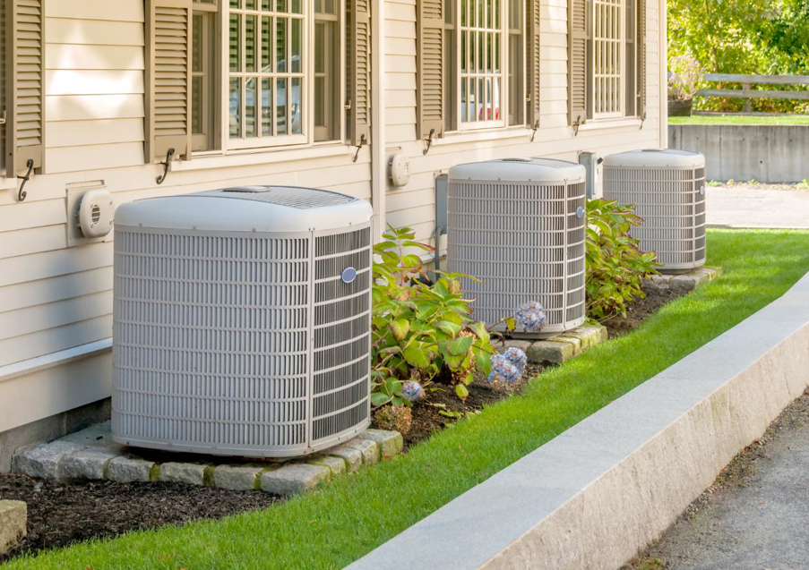 Three outdoor air conditioning units installed next to a residential building by Meyer's Air Conditioning & Refrigeration Co in Phoenix, AZ.