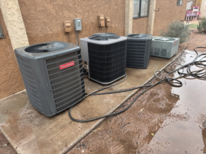Multiple outdoor air conditioning units ready for installation or service by LEWIS AIR LLC in Mesa, AZ.