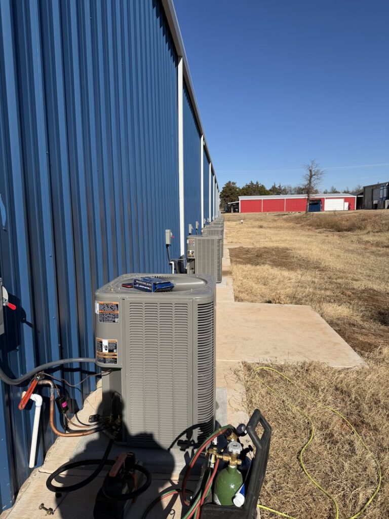 Multiple outdoor AC units installed along a commercial building by Oklahoma Climate Solutions in Oklahoma City, OK.