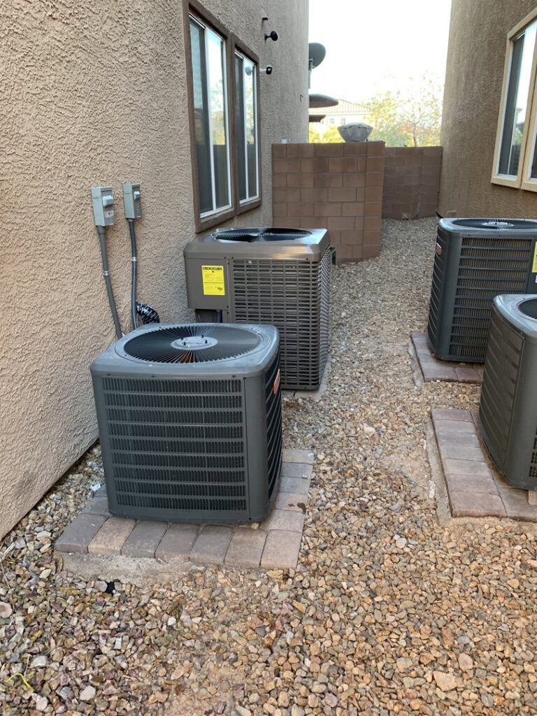 Multiple outdoor air conditioning units installed along a building by The Heating & Cooling Company LLC in Las Vegas, NV.