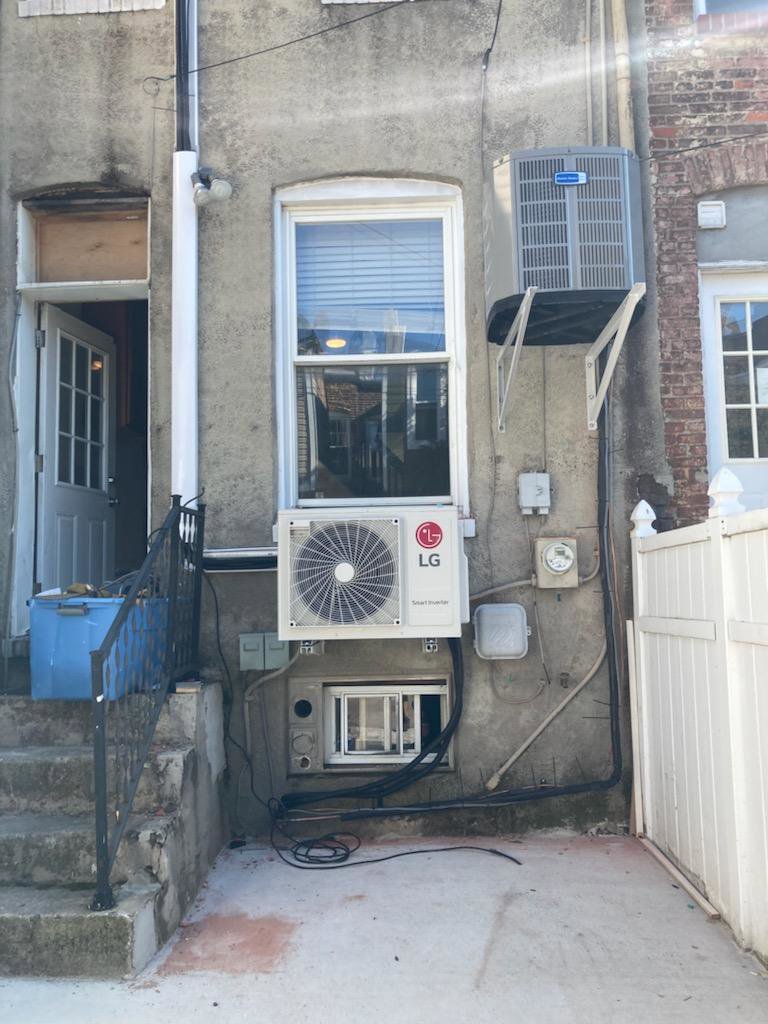 Multiple outdoor HVAC units, including an LG mini-split condenser, installed on the exterior of a building by Tack Mechanical LLC in Baltimore, MD.
