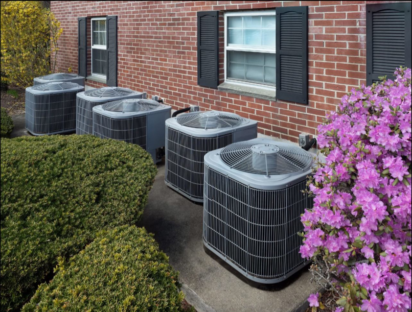 Multiple outdoor HVAC units lined up next to a commercial building, serviced by My Mechanical Heating and Cooling in Lancaster, PA