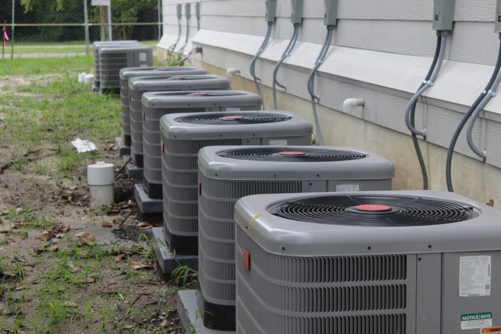 Multiple outdoor HVAC units installed along the side of a building by Comfort Shield HVAC Services of NC in Smithfield, NC.