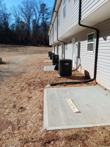 Multiple outdoor HVAC condenser units installed for a row of townhouses by Conway's Heating & Air in Concord, NC.