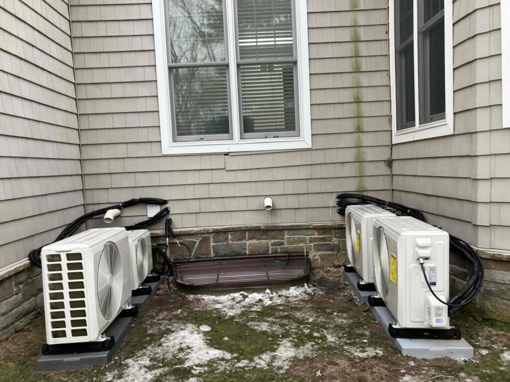 Installation of multiple outdoor mini-split condenser units next to a residential building by Ambiaire in Lakewood, NJ