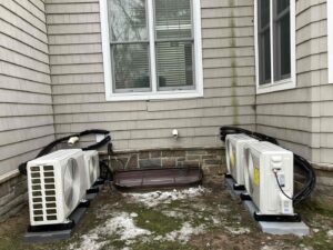 Installation of multiple outdoor mini-split condenser units next to a residential building by Ambiaire in Lakewood, NJ