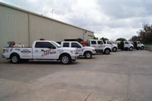 A fleet of Reliable Termite of OKC pest control trucks parked in a line, ready for service in Oklahoma City, OK.