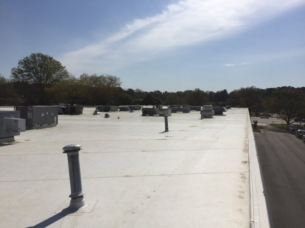Multiple rooftop HVAC units and vents on a commercial building, installed by Raleigh Comfort Services in Raleigh, NC.
