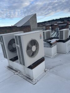 Multiple outdoor mini-split condenser units installed on a rooftop, serviced by Hvaclife in Minneapolis, MN.
