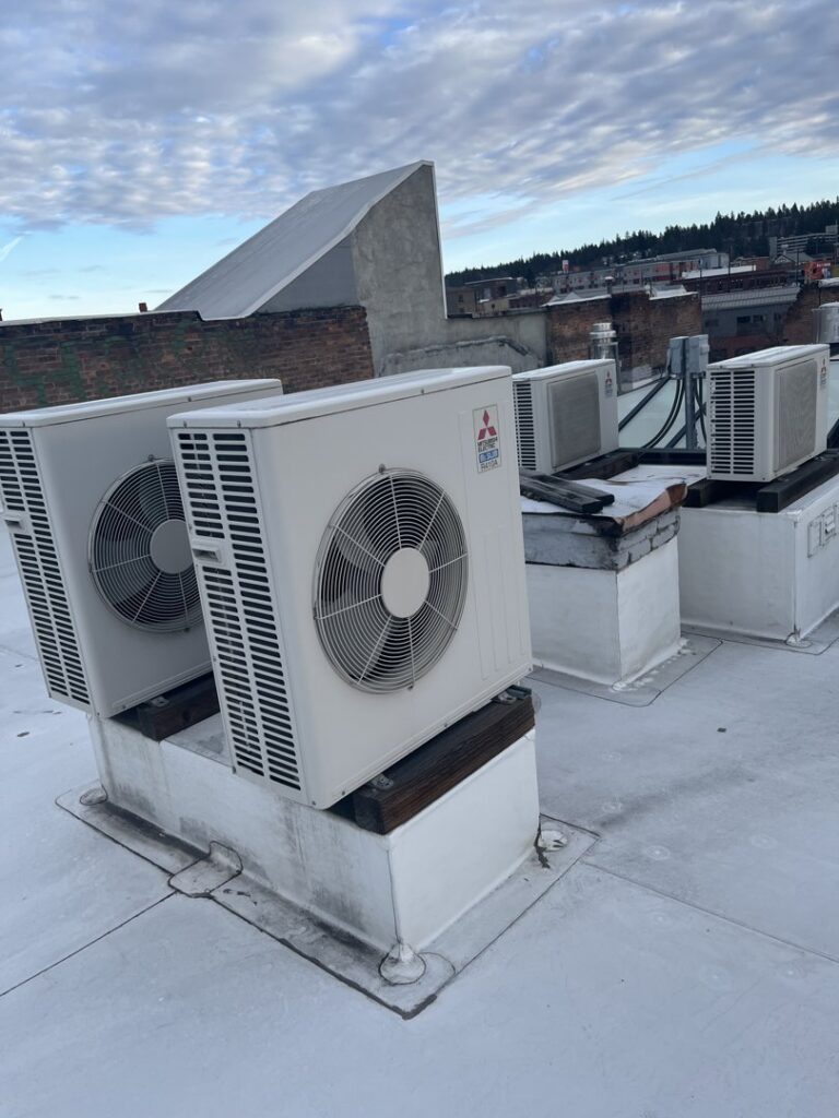 Multiple outdoor mini-split condenser units installed on a rooftop, serviced by Hvaclife in Minneapolis, MN.