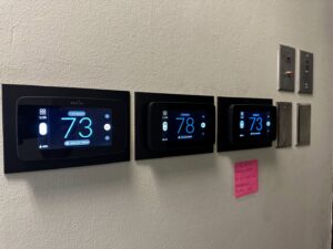 Multiple smart thermostats installed on a wall, showcasing modern HVAC control solutions by Elite Heat & Air in Monroe, LA.