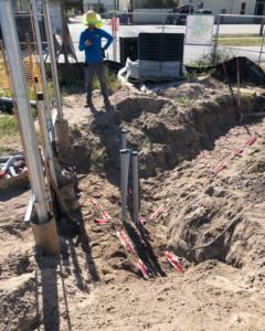 Multiple underground electrical conduits emerging from a trench, installed by Canseco Electrical Contractors, Inc. in Miami, FL.