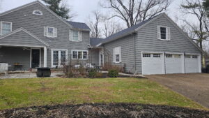 A large residential house featuring multiple white garage doors, installed by A+ Garage Door Repair in Evansville, IN.