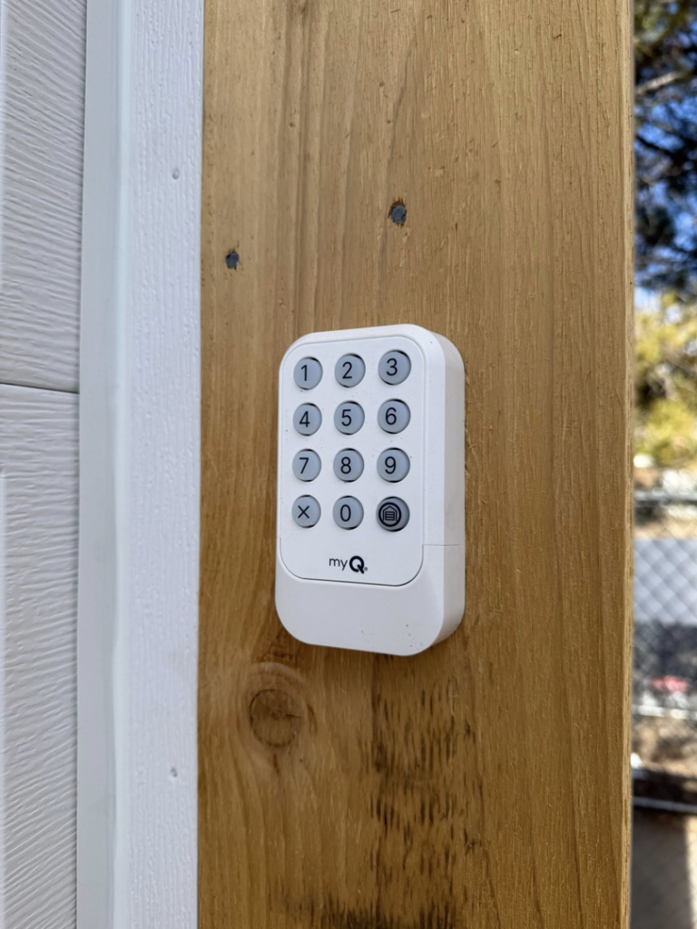 A newly installed myQ garage door keypad on a wooden post by 365GarageDoor in Dallas, TX