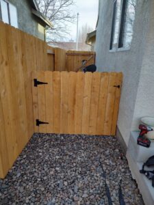 A newly installed wood fence and gate in a narrow side yard, providing secure access from Good Neighbor Fencing, LLC in Colorado Springs, CO.