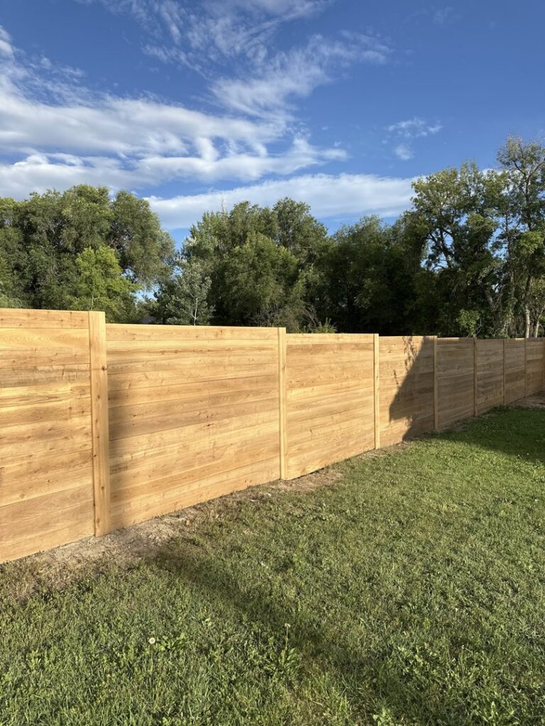 A newly installed natural wood horizontal slat fence in a residential yard by All Over Fence Idaho in Jerome, ID