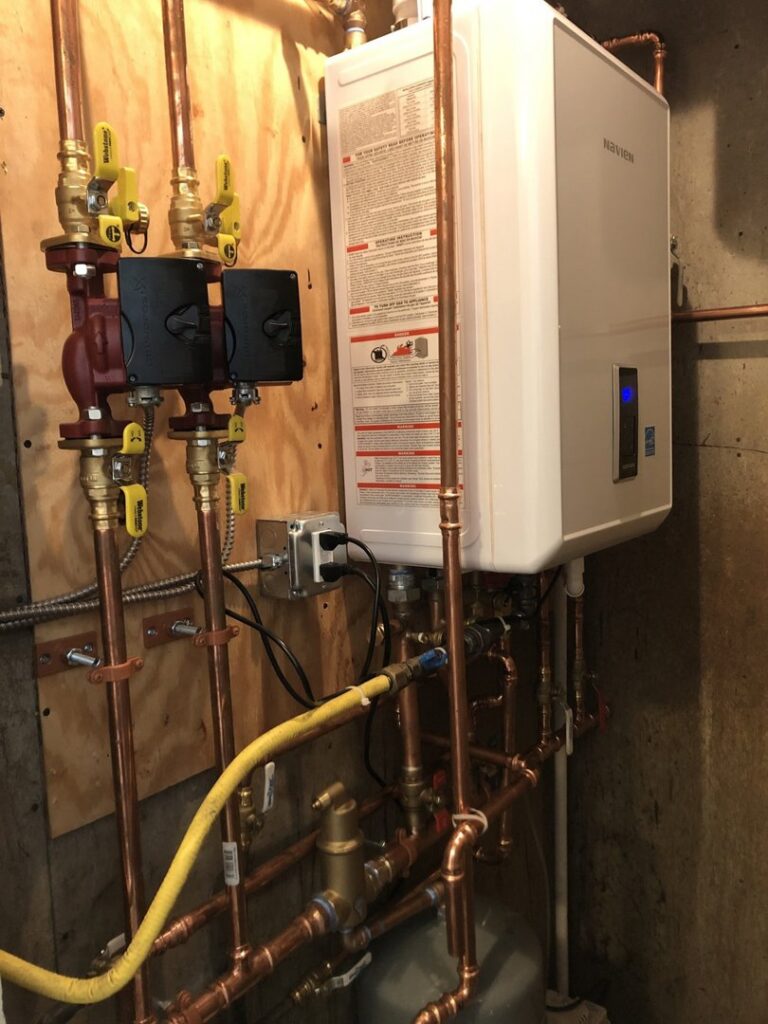 A Navien tankless boiler system with copper piping and pumps installed by Climate Care Heating & Air Conditioning in Norwalk, CT
