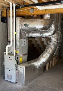 A Navien tankless water heater and heating system installed against a plywood wall by Dane HVAC in Willowbrook, IL.
