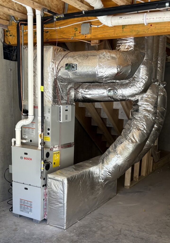 A Navien tankless water heater and heating system installed against a plywood wall by Dane HVAC in Willowbrook, IL.