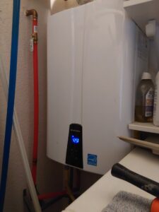 A Navien tankless water heater with a digital display, installed by Comfy Cave Heating and Air Conditioning in Arvada, CO.