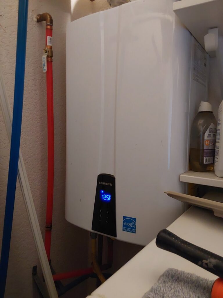 A Navien tankless water heater with a digital display, installed by Comfy Cave Heating and Air Conditioning in Arvada, CO.