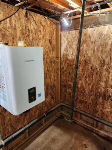 A newly installed Navien tankless water heater in a utility room by D & D Heating & Air in Brighton, CO.