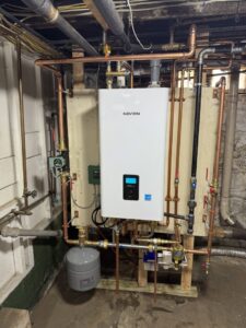 A Navien tankless water heater installation with copper piping by HomeWorks Energy in Medford, MA.