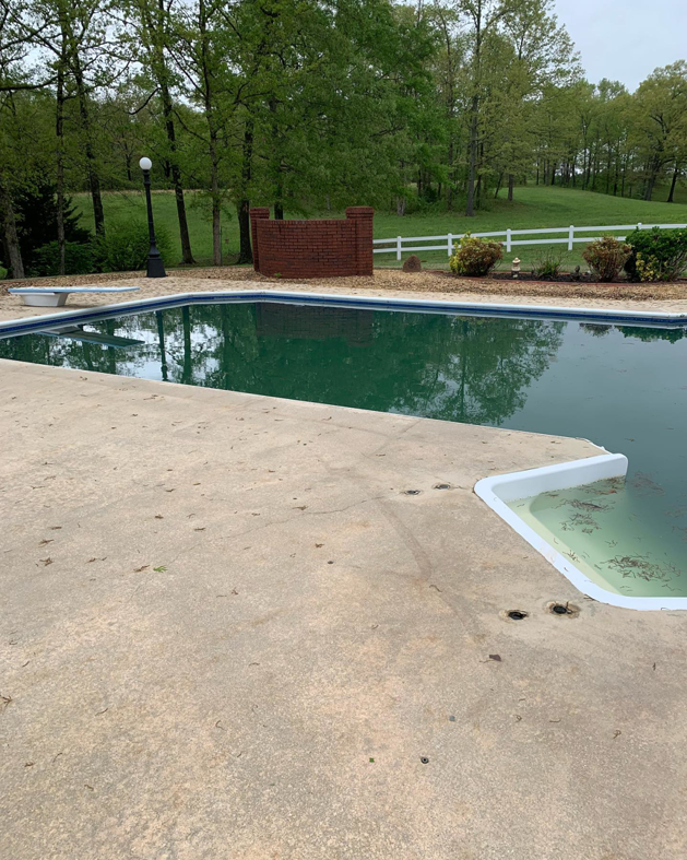 A neglected green swimming pool with debris, awaiting service from Pool Maid Pro in Decatur, AL.