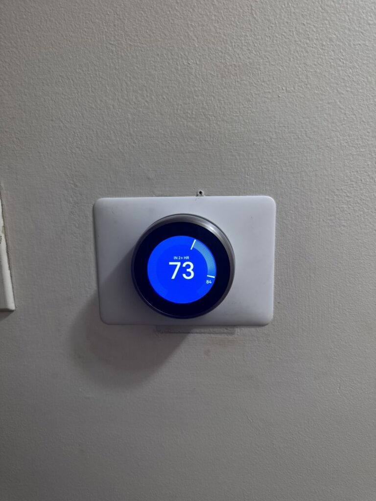 A Nest smart thermostat installed on a wall by ICare Heating & Air in Millcreek, UT.