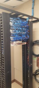 Neatly organized blue ethernet cables in a server rack, installed by KS Retail Solutions in Victoria, TX