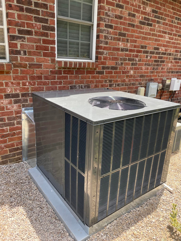 A newly installed outdoor AC unit next to a brick house by MTZ Heating and Air Conditioning in Charlotte, NC.