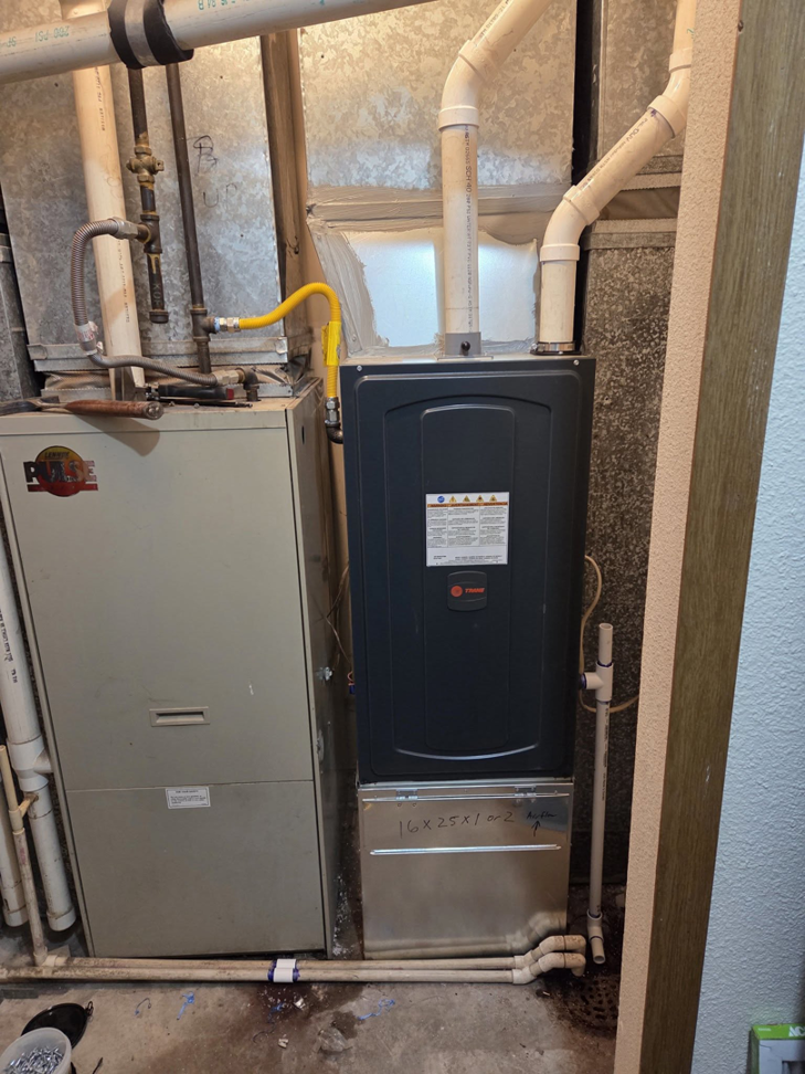 A new Trane furnace installed next to an older unit with ductwork and piping by High Standard HVAC LLC in Cheyenne, WY.