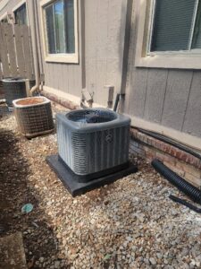 A new HVAC condenser unit installed next to an older unit by Integrity Services Heating and Cooling in Madison, AL.