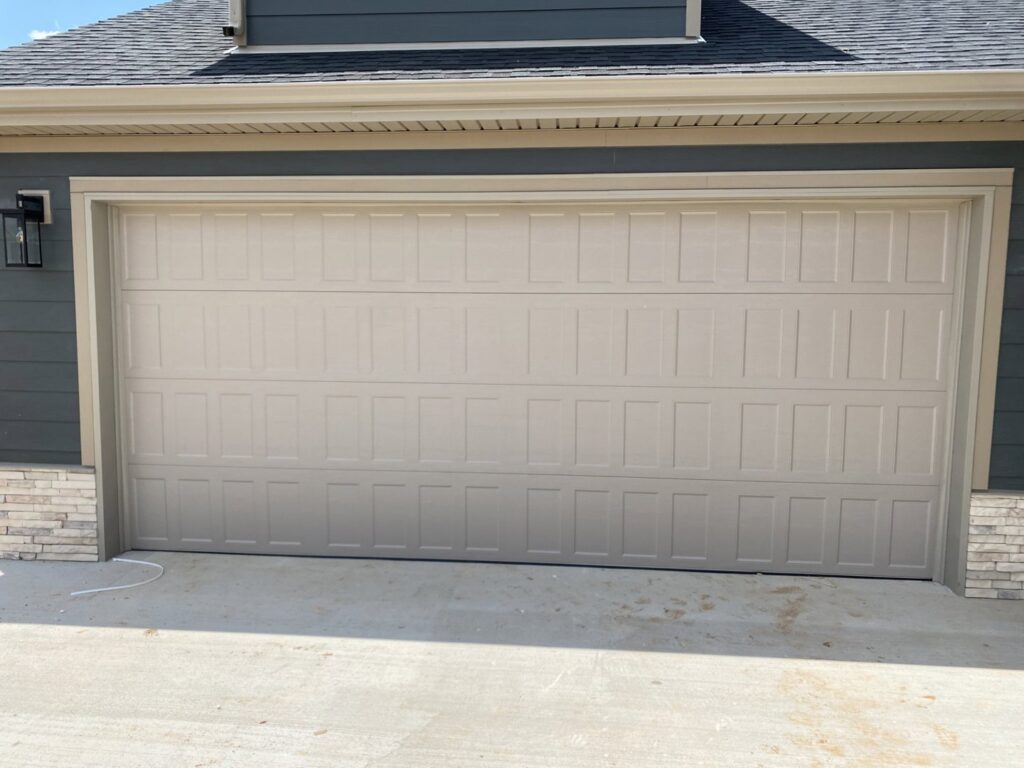 A newly installed beige panel garage door on a modern home by Smith's Garage Door in Clarksville, TN.