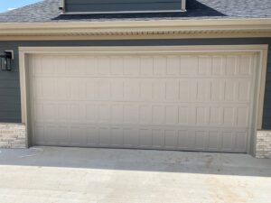 A newly installed beige panel garage door on a modern home by Smith's Garage Door in Clarksville, TN.