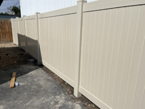 A newly installed beige vinyl privacy fence by Border Fence, Inc. in Greeley, CO.