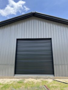 A newly installed black commercial roll-up garage door by Chase Door Systems in Summerville, SC.