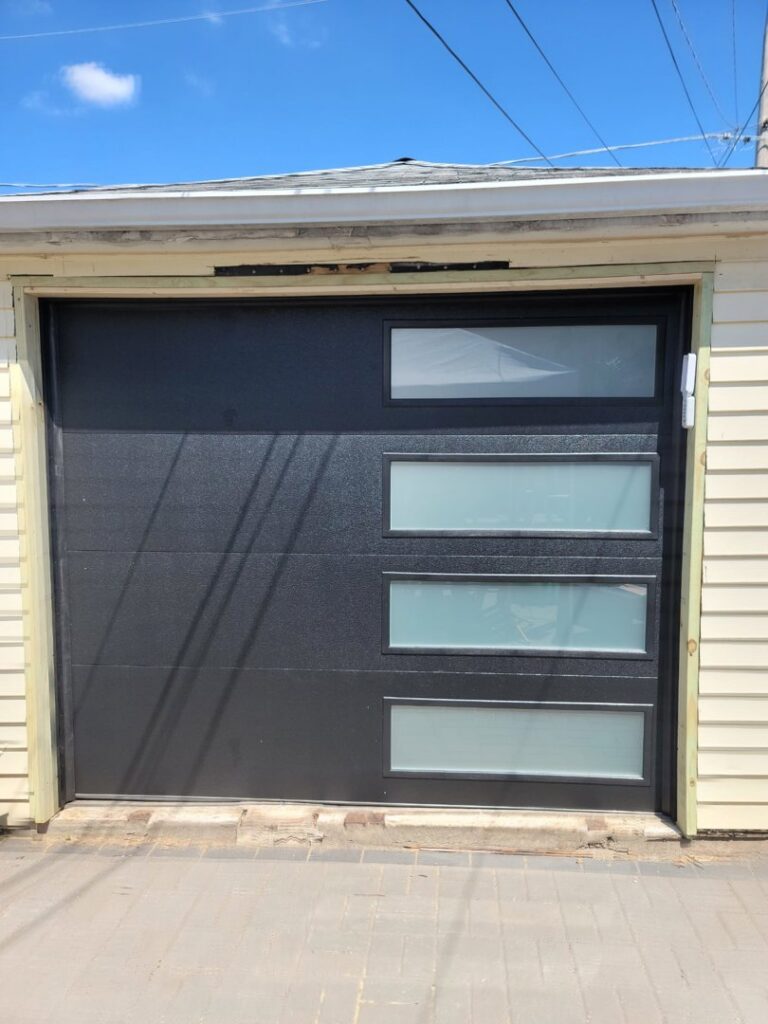 A newly installed black garage door with modern windows by The Region's Garage Door Repair in Hammond, IN.
