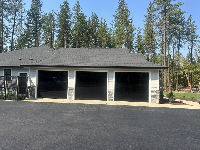 A newly installed set of three modern black garage doors on a residential property by Reed's Garage Door Systems LLC in Sutherlin, OR.