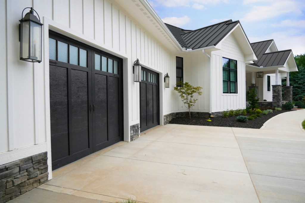 Newly installed black garage doors on a modern white home by Precision Garage Door Service in Lafayette, LA.